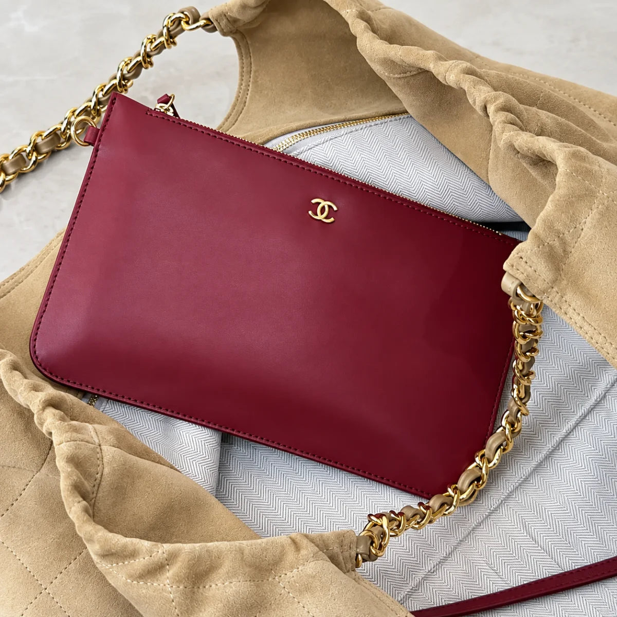 Red zip pouch shown inside beige quilted shoulder bag
