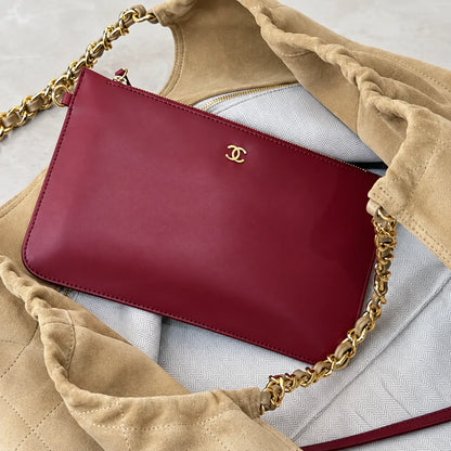 Red zip pouch shown inside beige quilted shoulder bag